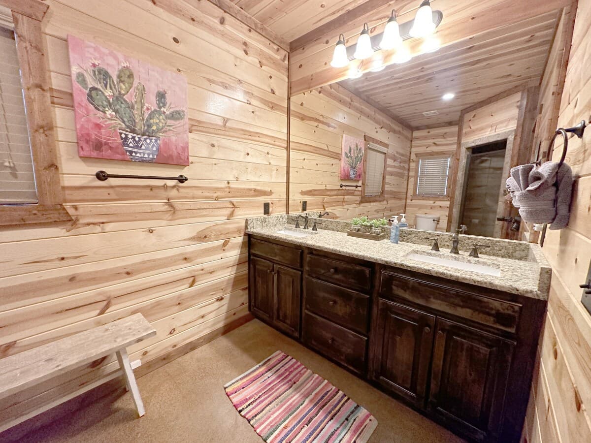 Bathroom at Livin' the Dream with a long double vanity, granite counters and cactus art