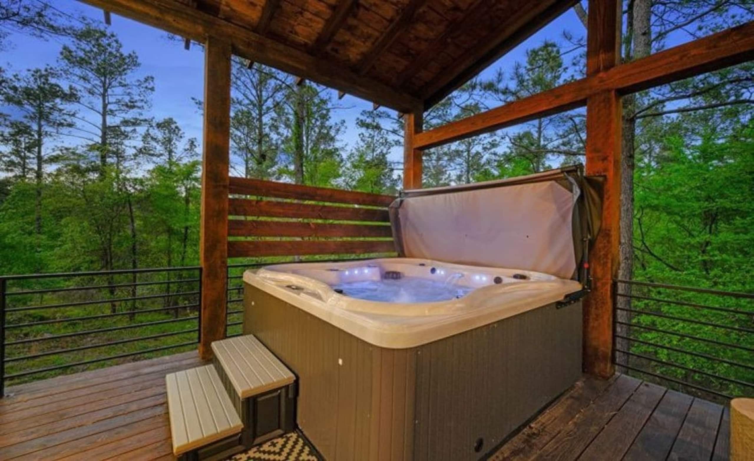 Hot tub on the covered deck at Sublime Retreat, looking out into the pine forest