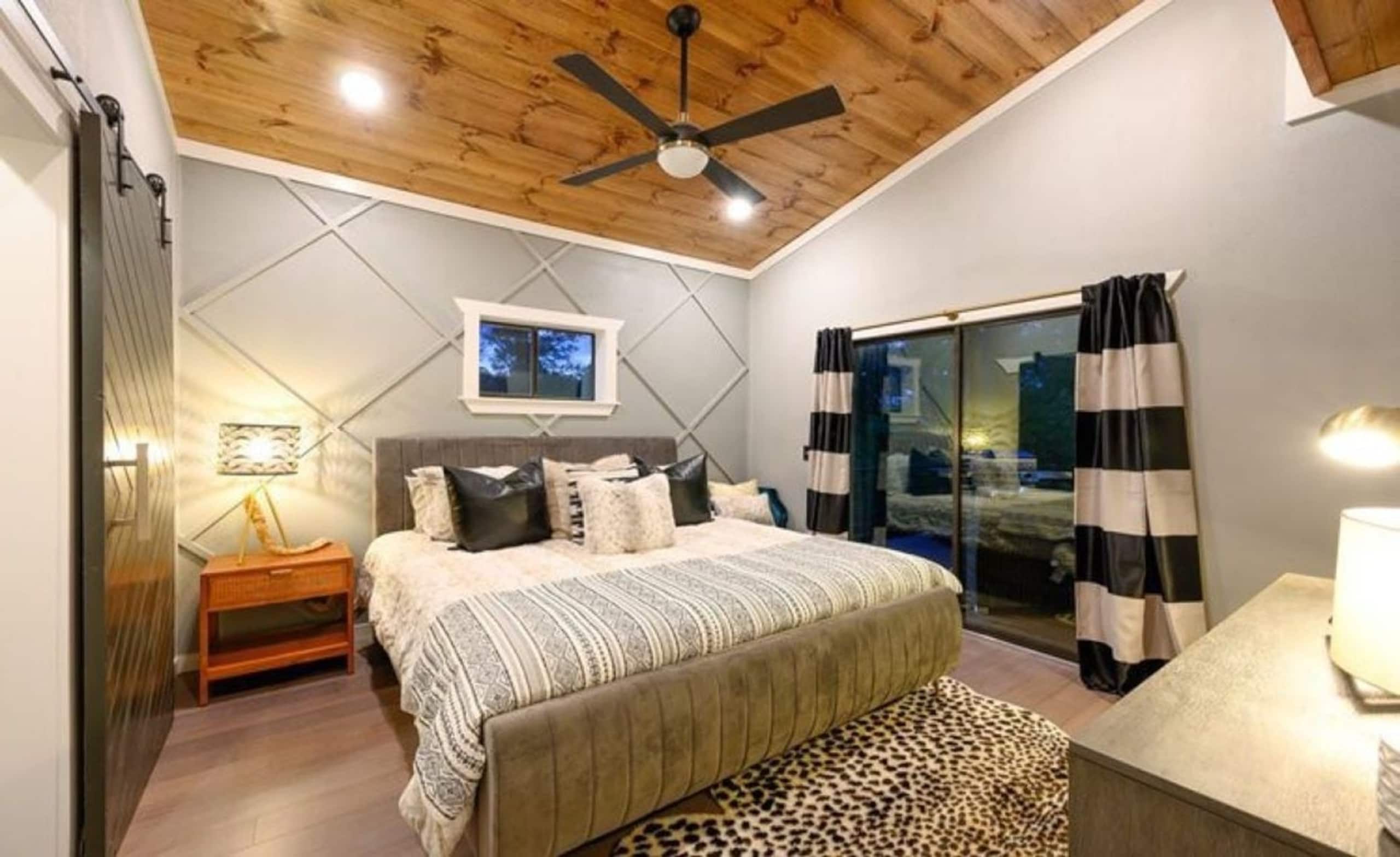 Second king suite at Sublime Retreat with a king bed, striped curtains and a sliding door to its patio